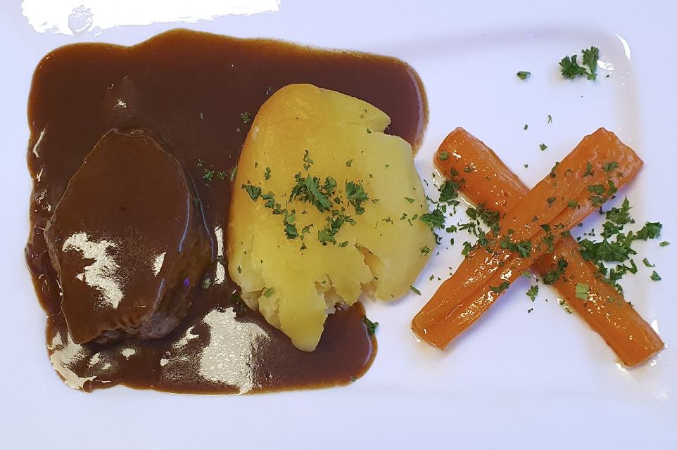 6. Gang, Collops with braised red onions & mashed potatoes. Aber was dedeutet das X auf dem Teller??